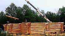Crane lifting logs into place at Heartwood's work site.
