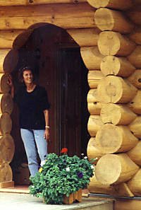 Massive peeled logs frame the doorway to a log home